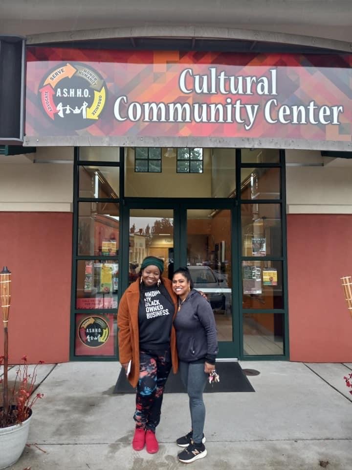 Khurshida Begum, right, is shown with a supporter in front of the entrance to ASHHO's Cultural Community Center in Tumwater.